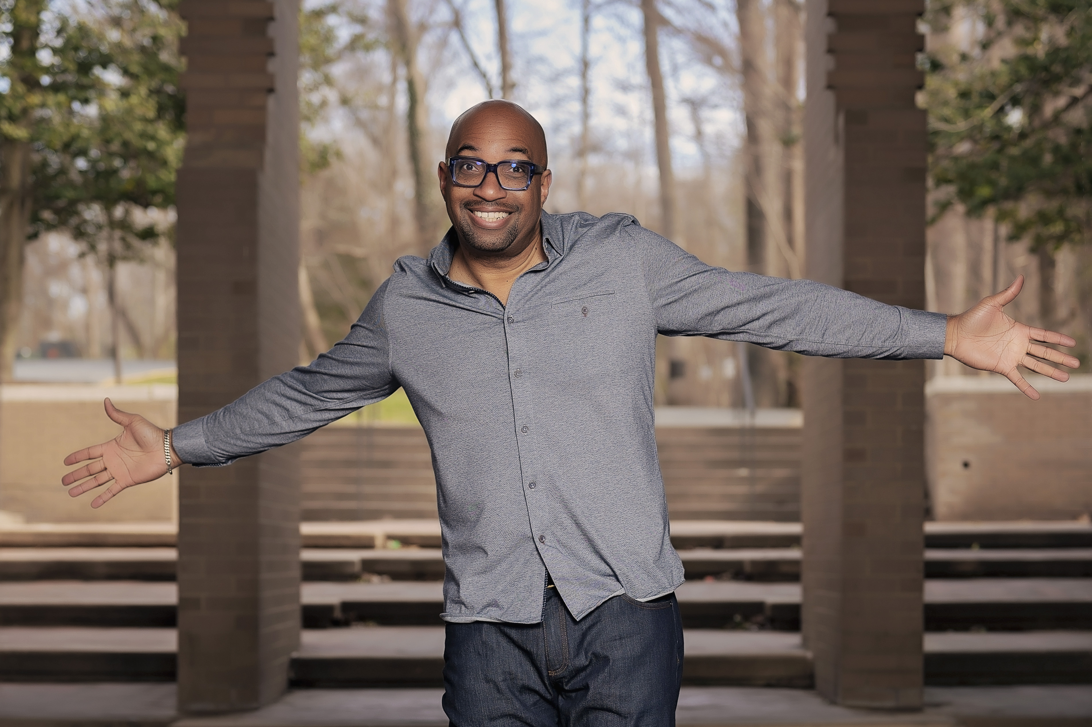 author Kwame Alexander standing with his arms flung wide open
