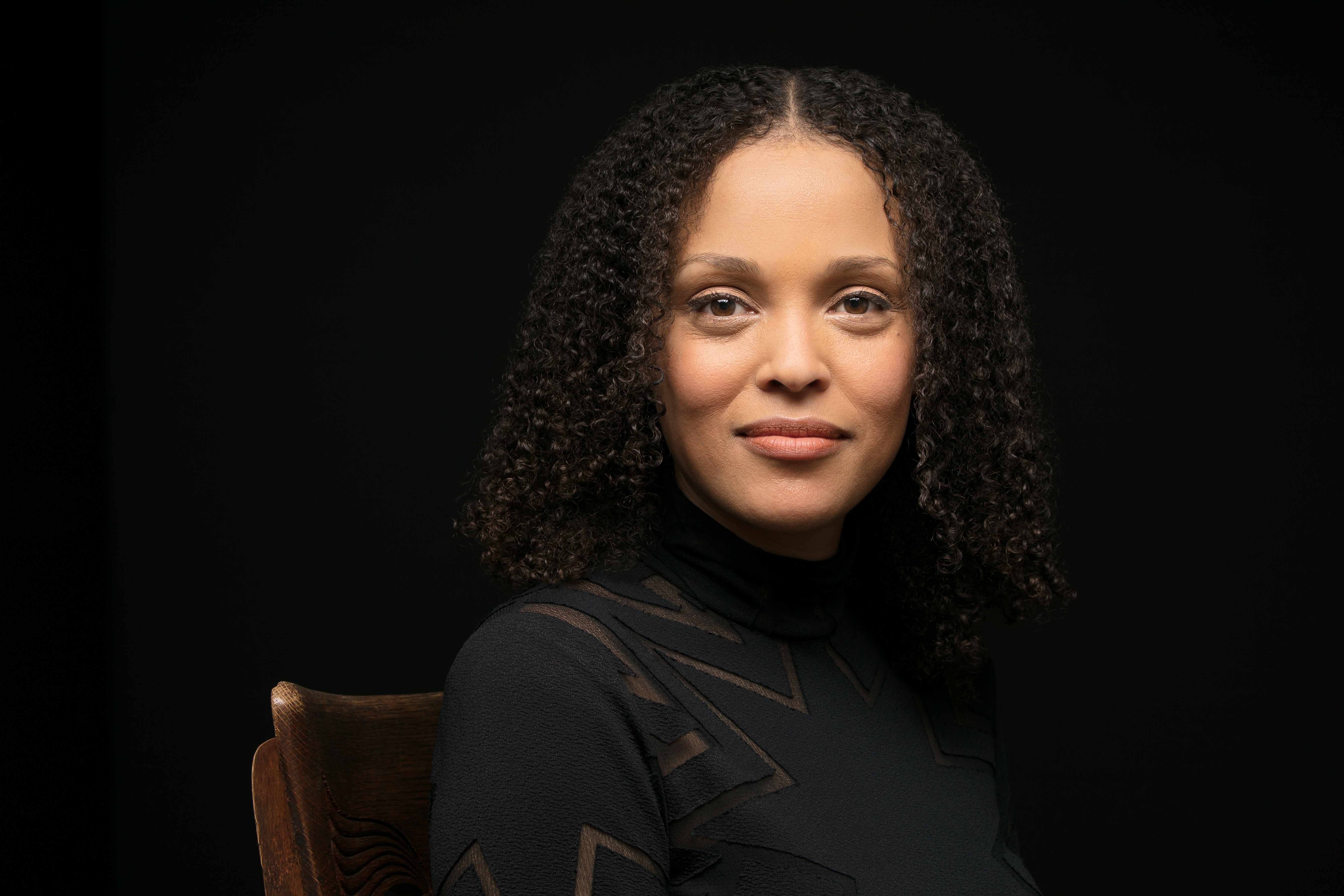 photo of author Jesmyn Ward wearing a black turtleneck looking directly at the camera