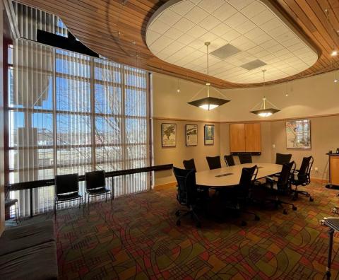 Photo of Boardroom including a conference table, 9 chairs around it and additional seating off to the side