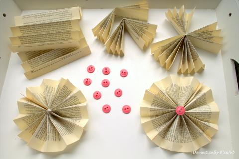 showing a paper rosette made out of old book pages in various degrees of progress