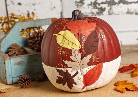 a pumpkin decorated with mod podged leaves, very fall-like and pretty