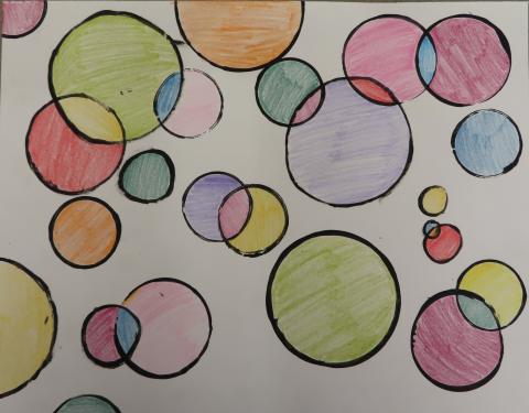 differently sized black circles colored in with pencils