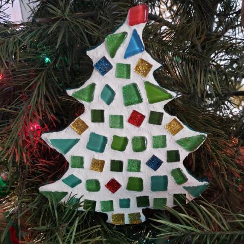 tile mosaic holiday tree ornament hanging from a real pine tree