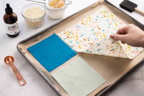 pieces of cloth, about to be turned into reusable beeswax wraps, lying on a baking sheet