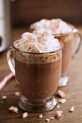 a small mug of hot chocolate towering with whipped cream