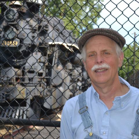 Mike Matejka standing by an old-school train engine