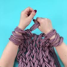 two arms with purple yarn wrapped around them for yarn knitting