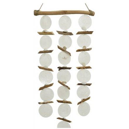 wall art made from a branch and hanging capiz shells