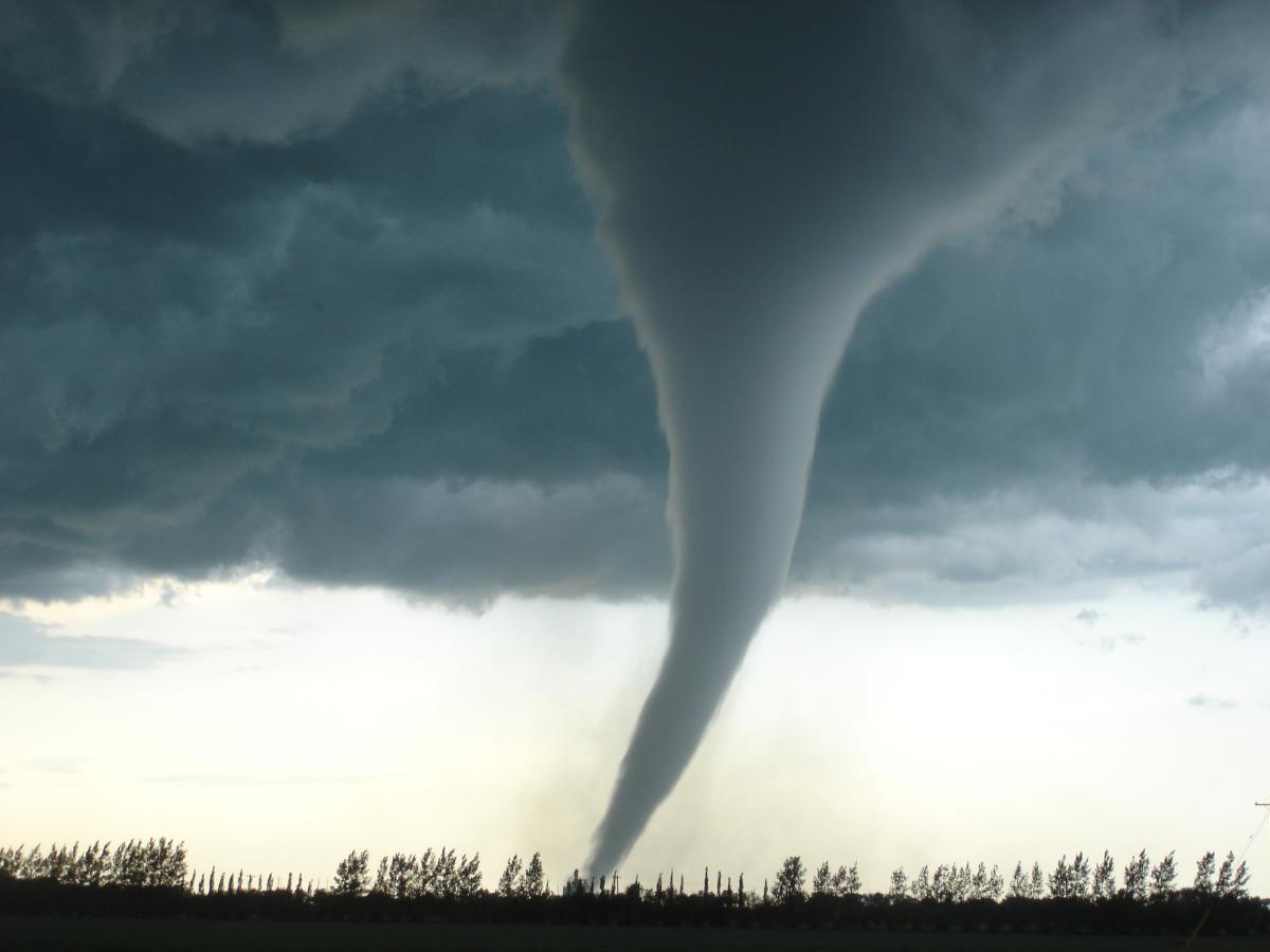 picture of a tornado touching down in a flat field