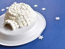 an igloo made out of mini marshmallows in a white plate with a blue background