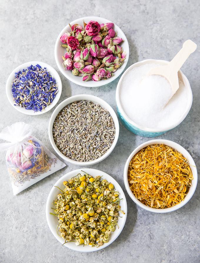 an aerial view of a table with six bowls, each holding different herbs