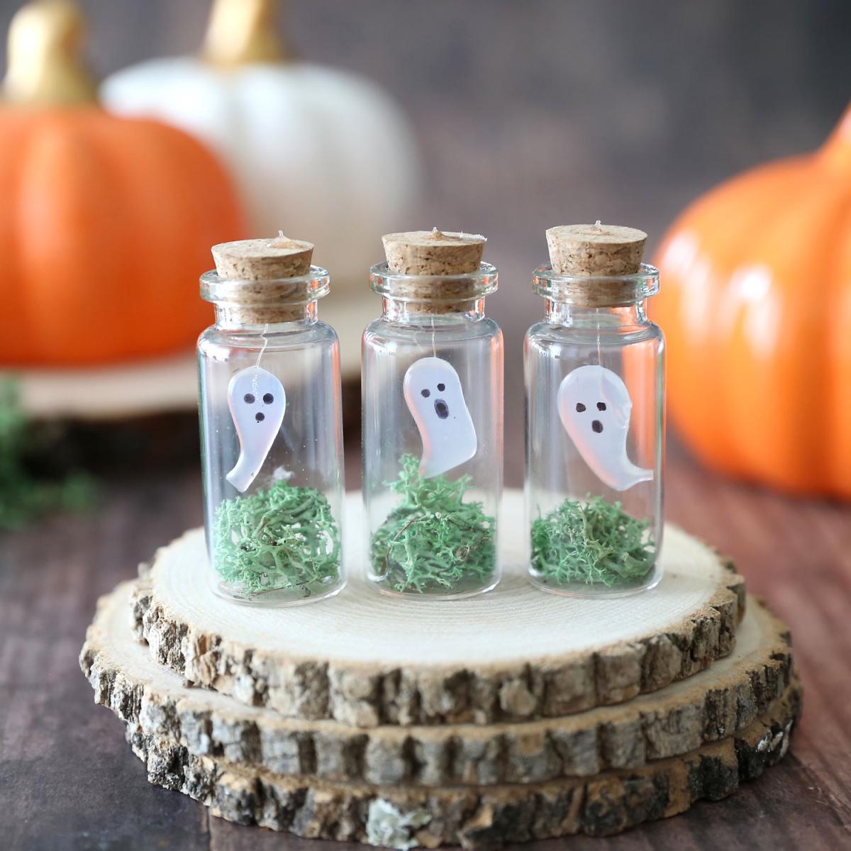 three small jars each containing tiny ghosts with different levels of "spooky" faces