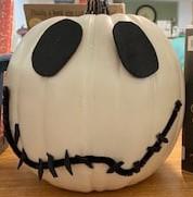 white pumpkin with black eyes and mouth painted on