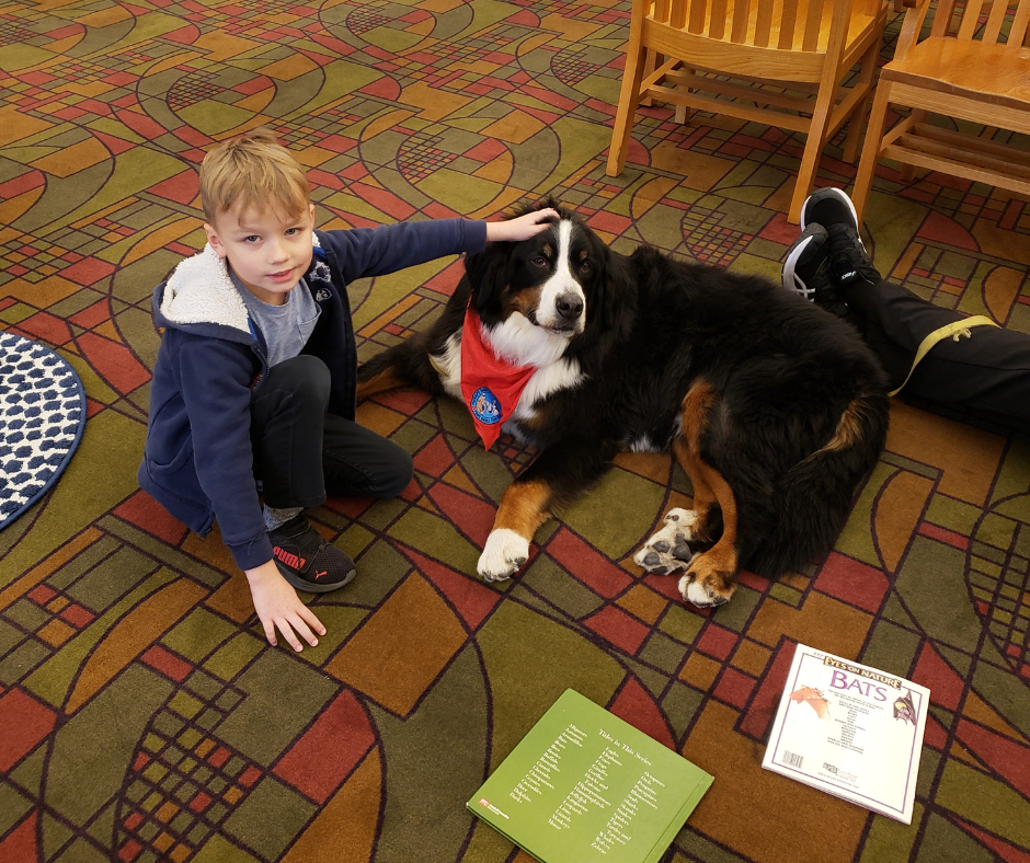 child reading to dog in the library